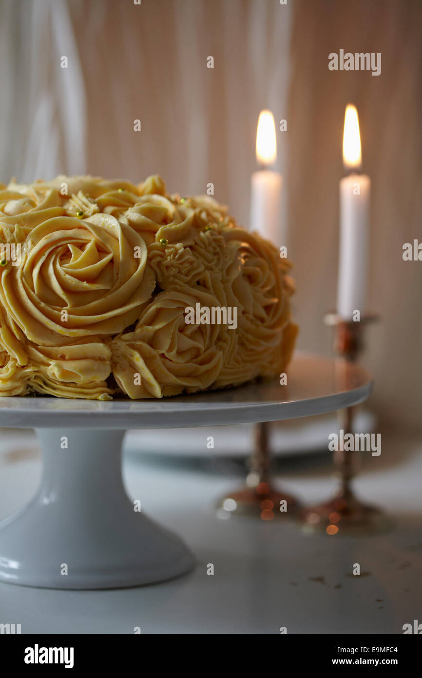 Torta di rose e candele sul tavolo Foto Stock
