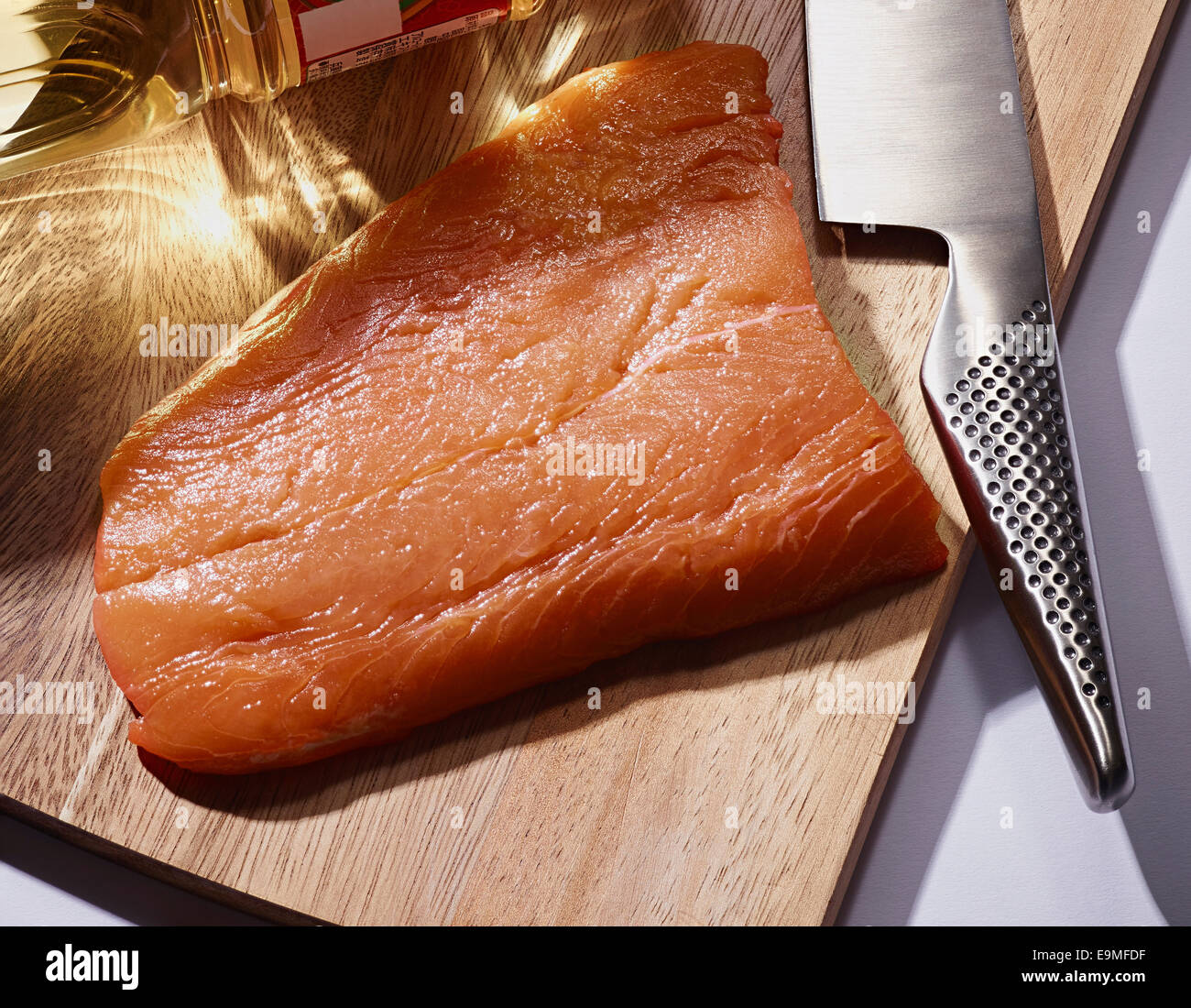 Angolo di Alta Vista della fetta di salmone e il coltello sul tagliere Foto Stock