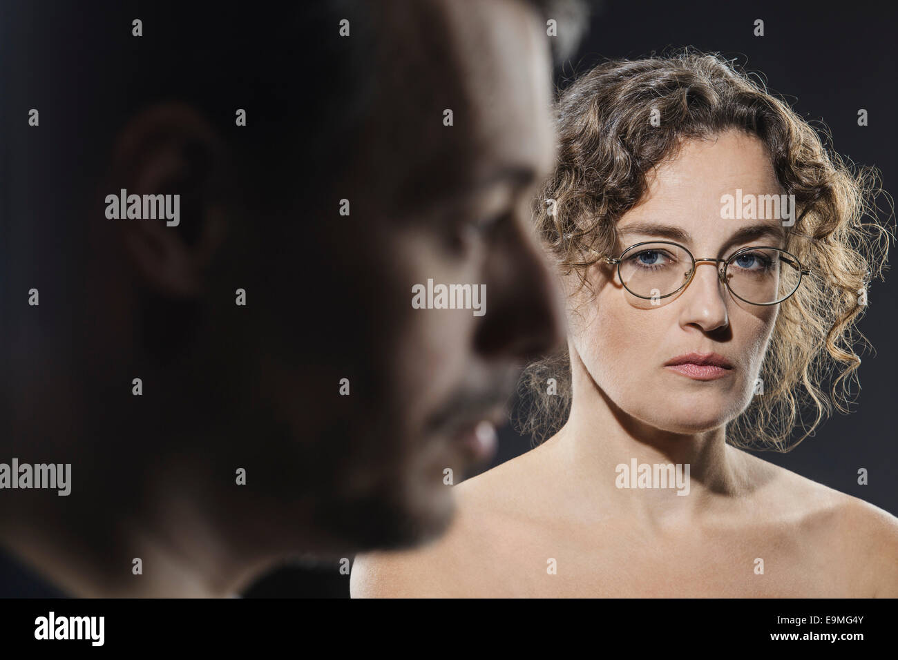 Ritratto di donna seria con uomo in primo piano Foto Stock