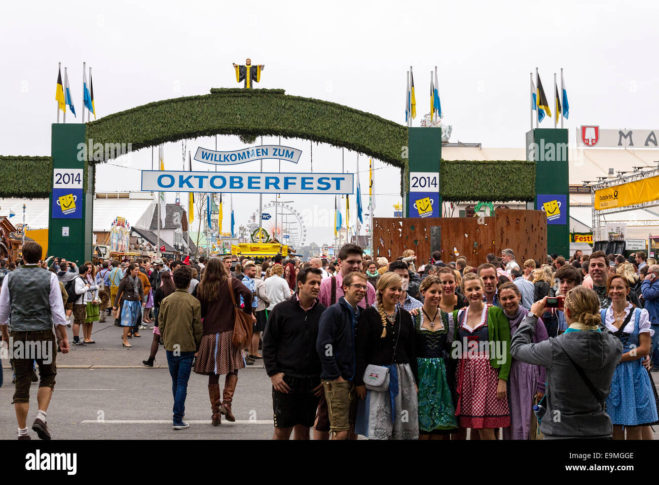 Felici le persone aventi una foto di gruppo preso di fronte alla Oktoberfest ingresso, Alta Baviera , Germania, Europa. Foto Stock