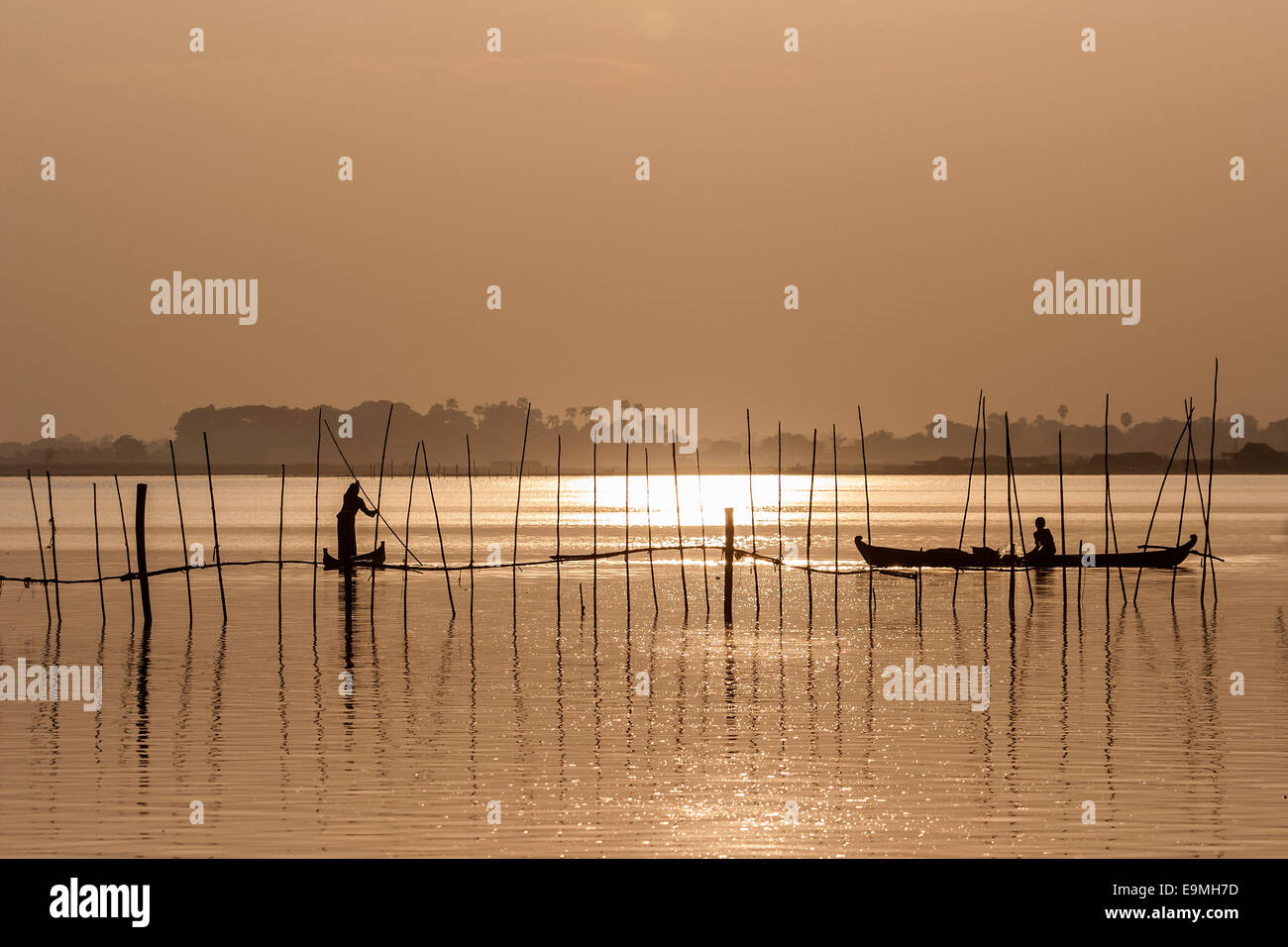 I pescatori in barche nella luce della sera, Lago Taungthaman, Mandalay Myanmar Foto Stock