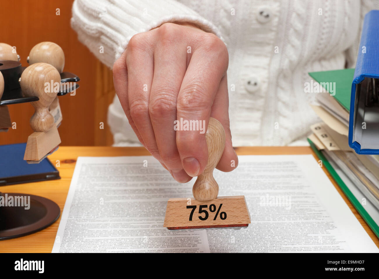 Un timbro con la scritta del settantacinque percento è tenuto in mano Foto Stock