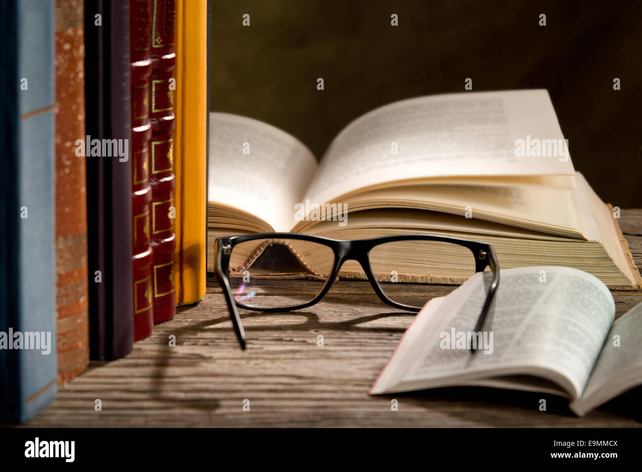 Gli occhiali da lettura con i libri sul tavolo Foto Stock