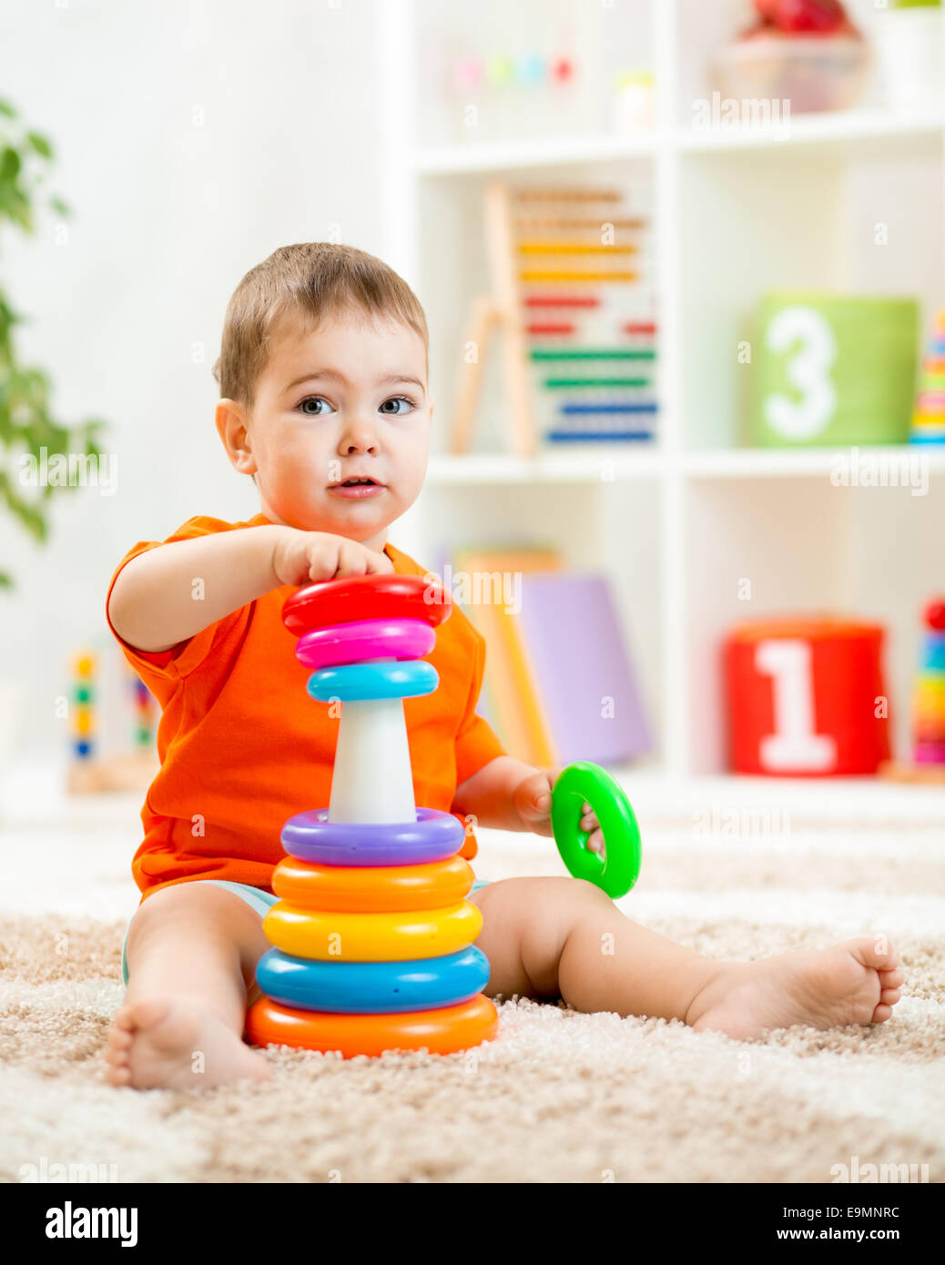 Carino kid a giocare con i colori del giocattolo indoor Foto Stock