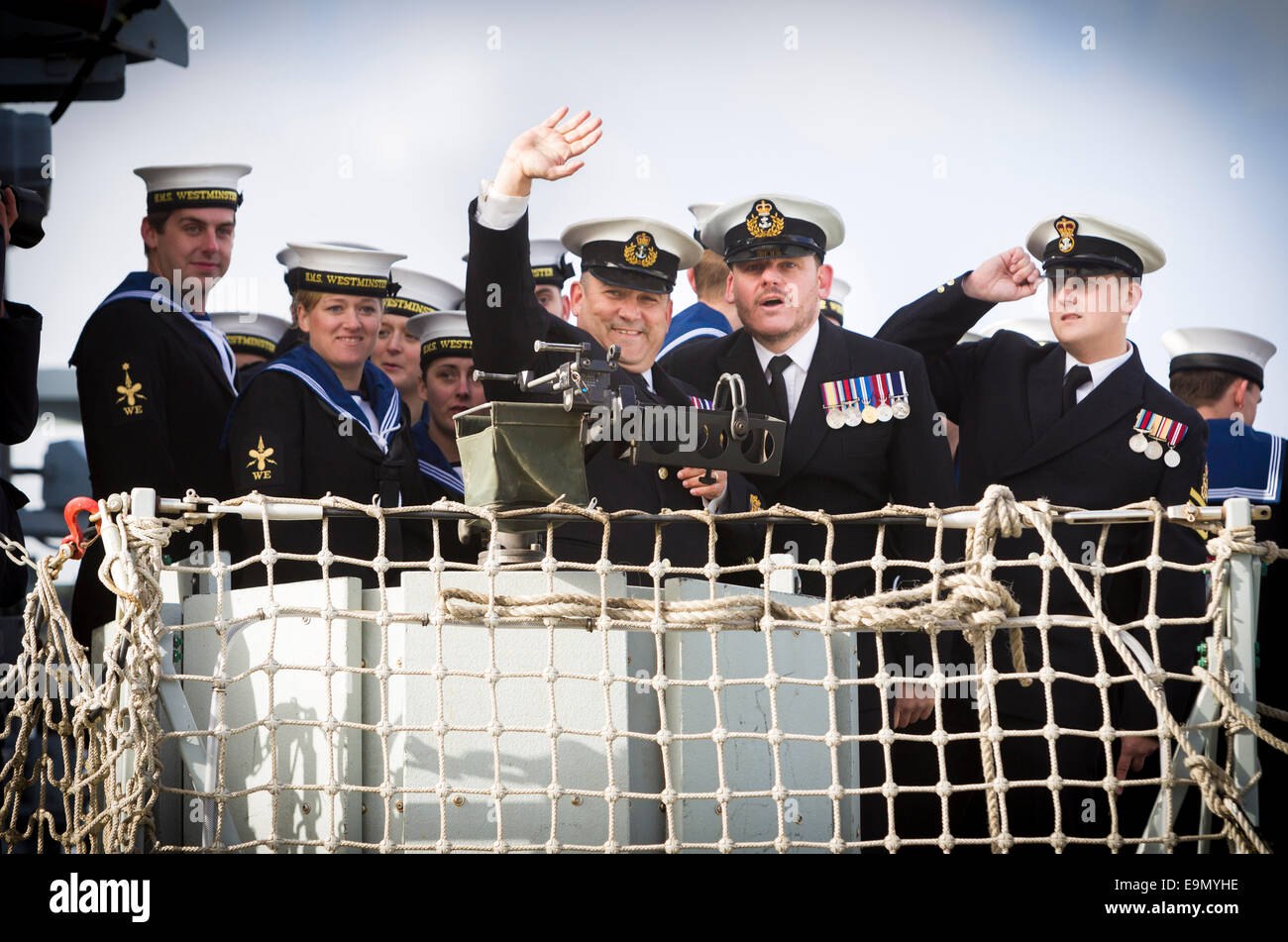 I marinai a wave di famiglia dal tipo 23 fregata HMS Westminster come lei ritorna a Portsmouth Royal Navy di base a seguito di sei e Foto Stock