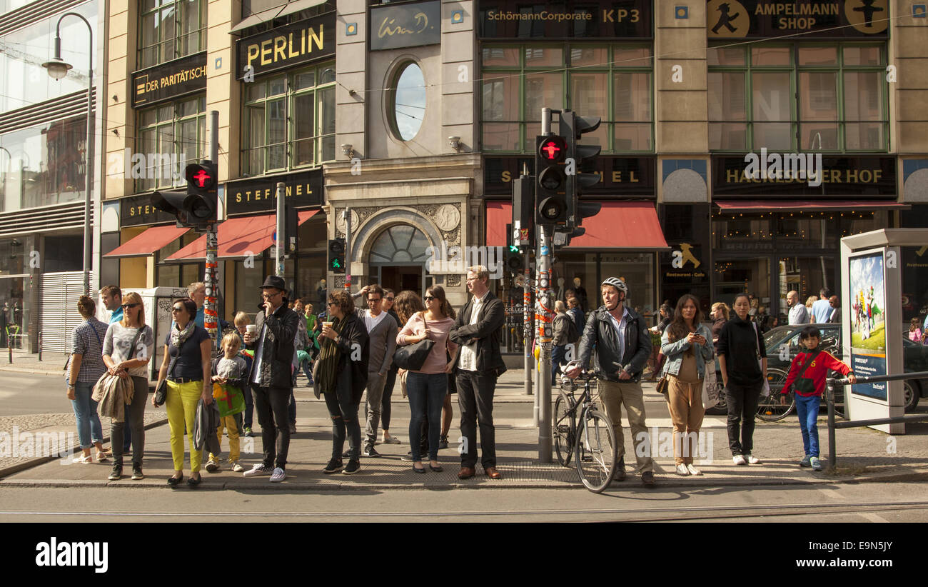 Persone in attesa per la luce per cambiare nel quartiere Mitte, sulla Rosenthaler Street, Berlino. Foto Stock