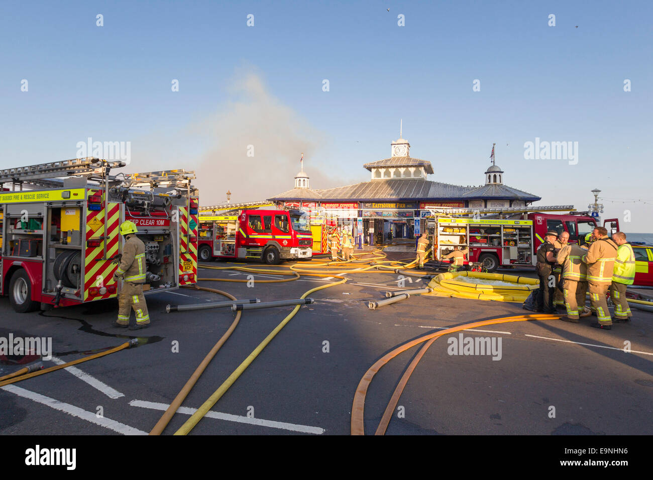 I vigili del fuoco da East Sussex fuoco e il servizio di soccorso smorzare giù le fiamme a seguito di un incendio di grandi dimensioni presso il molo di Eastbourne, Foto Stock