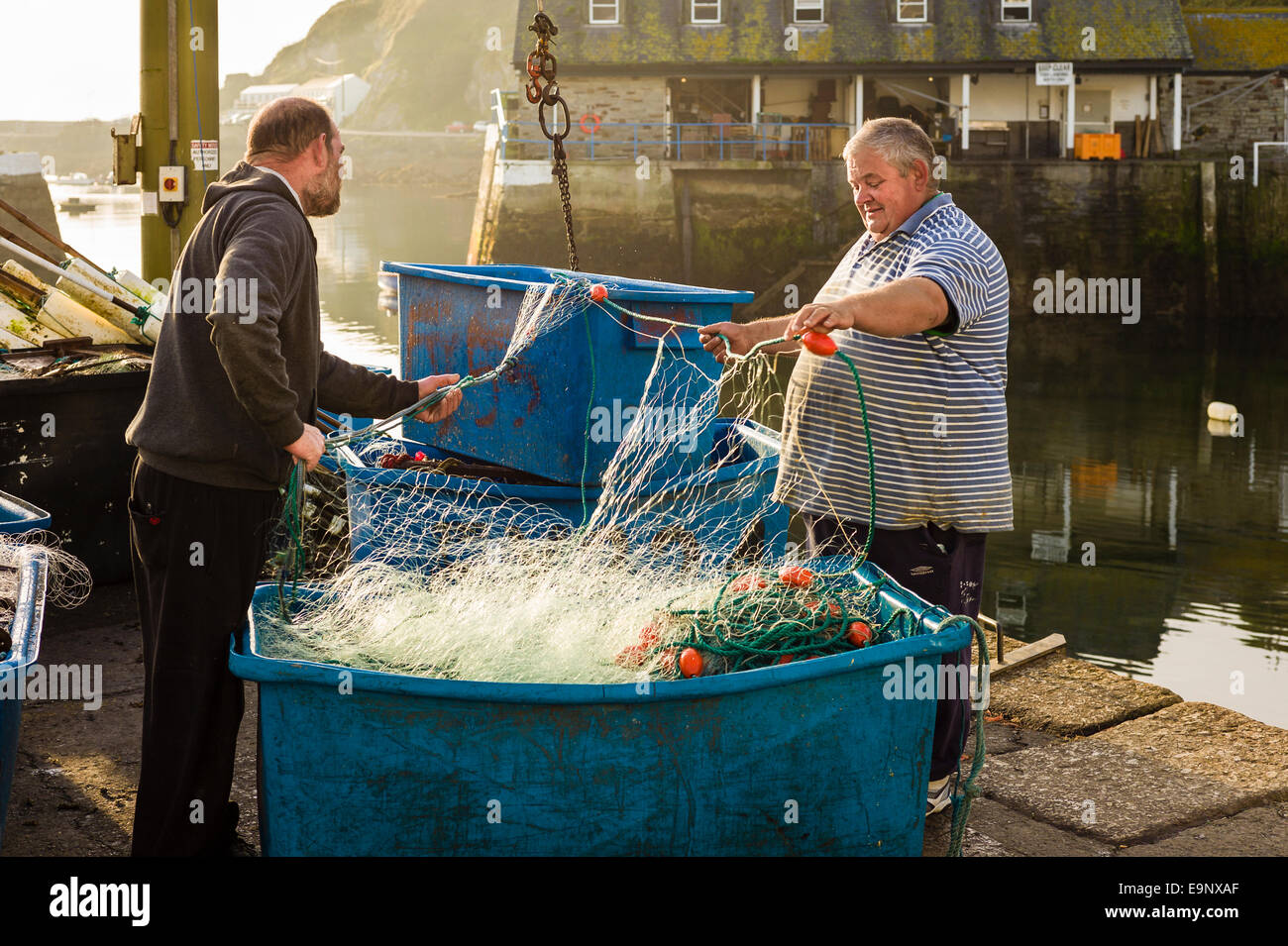 I pescatori in Mevagissey ispezione di reti da pesca prima di vela Foto Stock