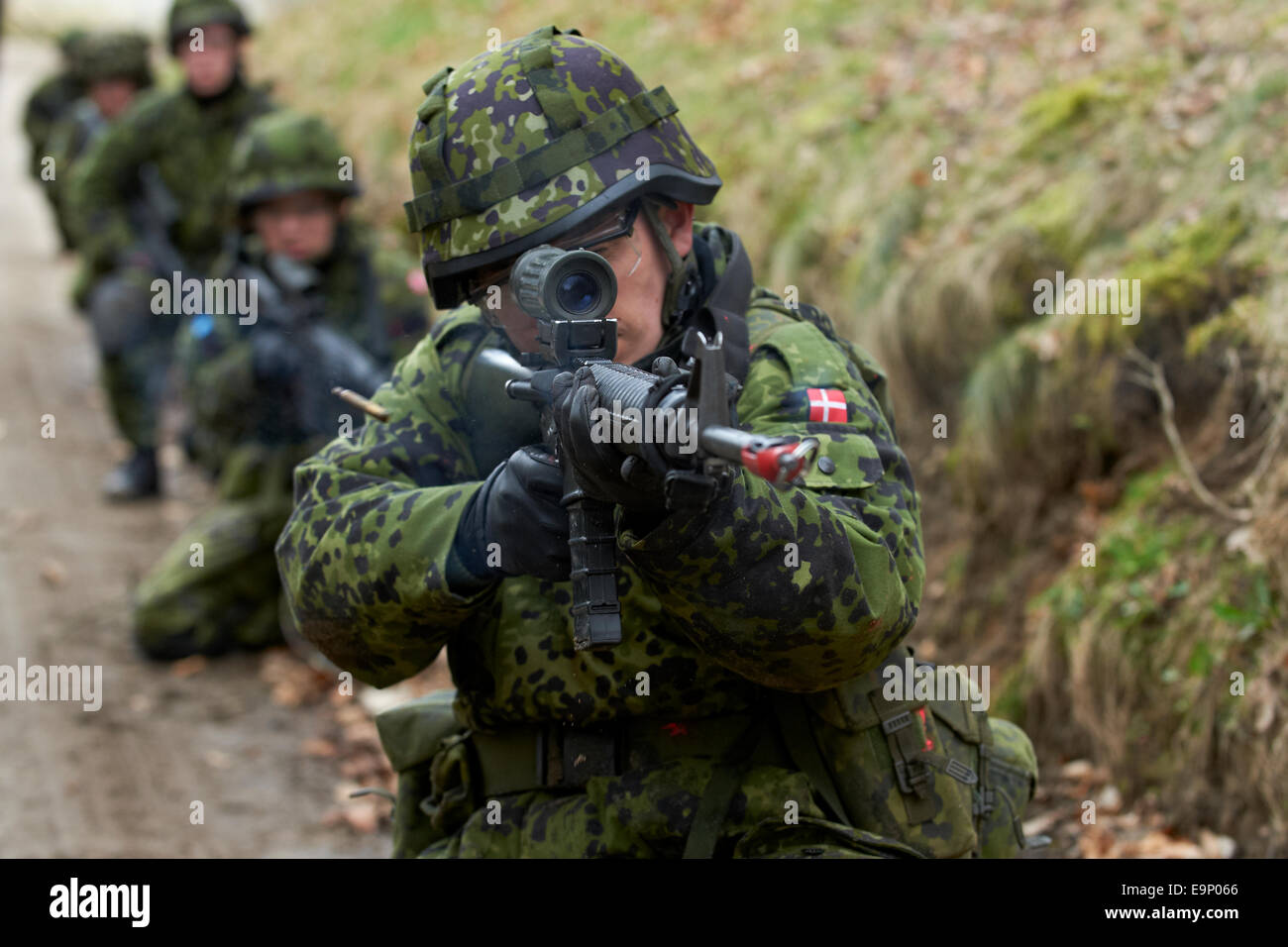 Durante l'addestramento al combattimento esercizi, un soldato danese incendi sbozzati con il suo fucile automatico M/95 (Colt (Diemaco) C7A1. Foto Stock