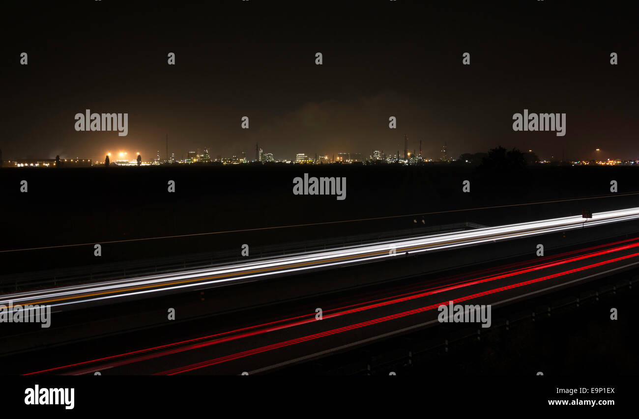 Auto sentieri con un impianto industriale sullo sfondo Foto Stock