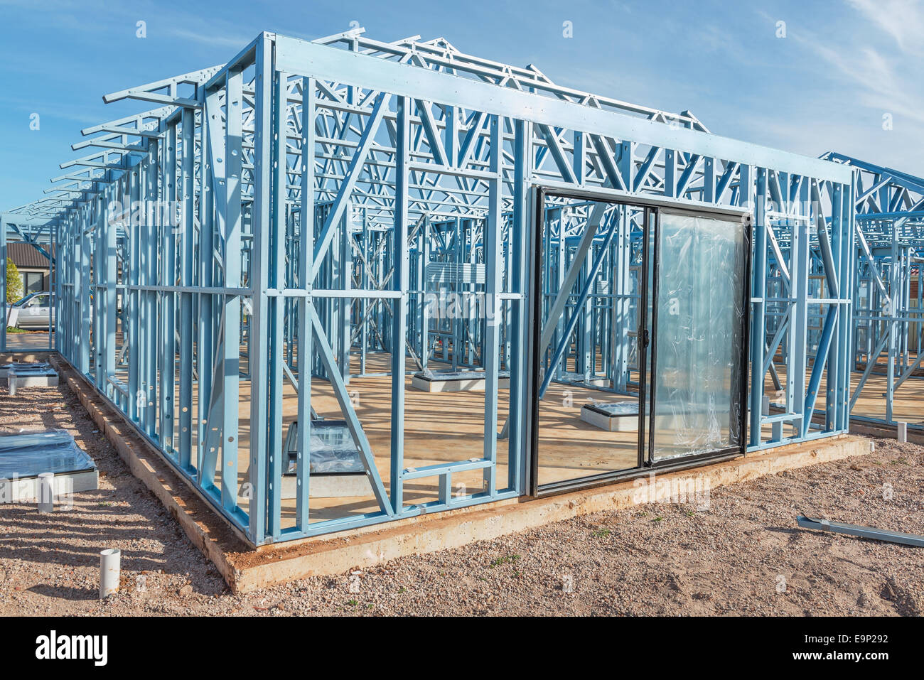 Nuova casa in costruzione utilizzando telai di acciaio contro il cielo blu Foto Stock