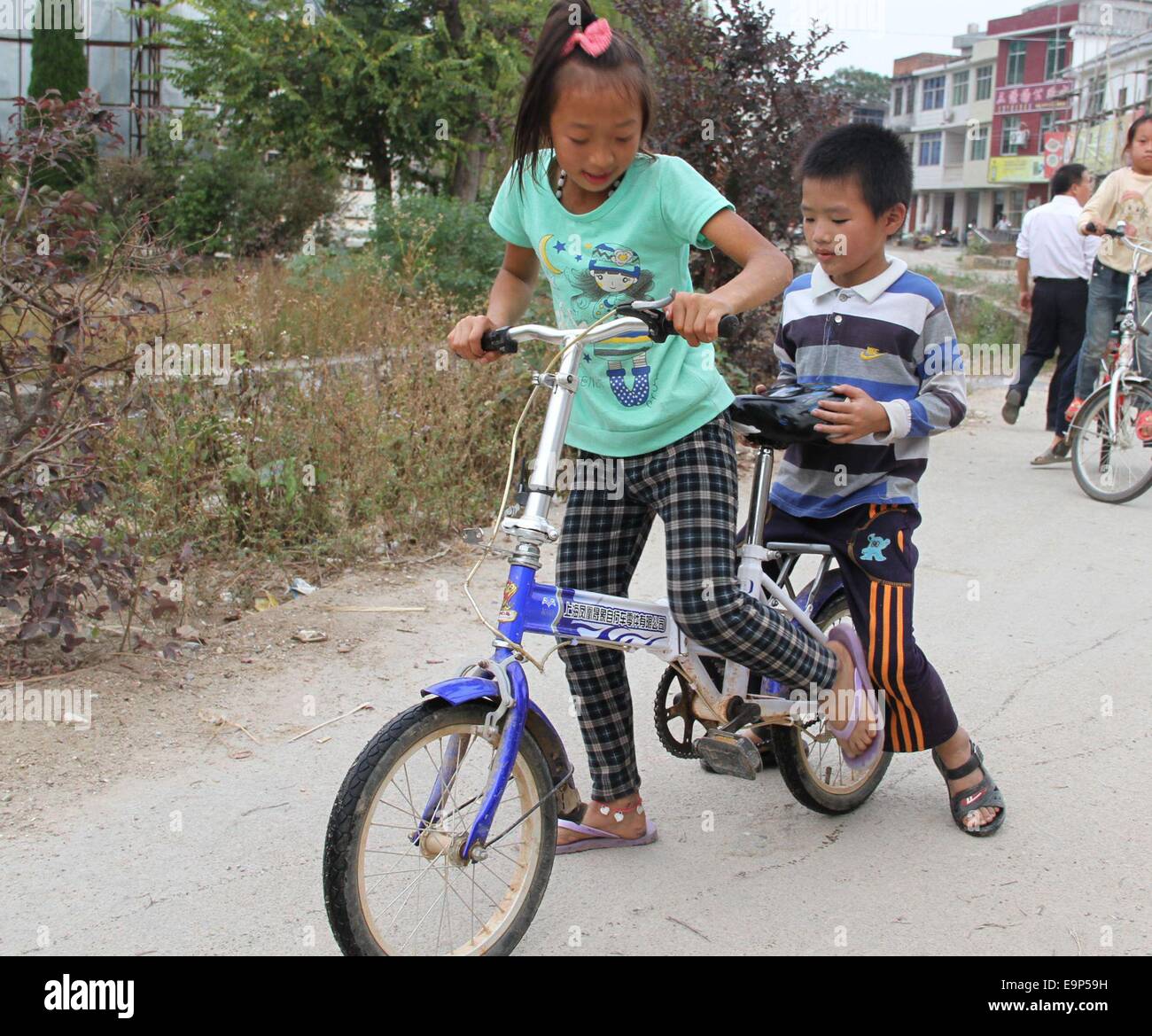 Ottobre 27, 2014 - (Cina) Solo per uso al di fuori della Cina. Non utilizzare per la vendita o per esporre in Cina. Cina XINGGUO Ott 30: sinistra-dietro i bambini la vita dopo la classe in Sanliao county, Ganzhou città, Jiangxi provincia della Cina. I loro genitori erano emigrati provenienti dalle zone rurali verso le città. Questo ha creato milioni di bambini lasciati alle spalle nelle aree rurali sotto la cura di parenti, principalmente i nonni con poca o nessuna istruzione, amici di famiglia, o di dover prendersi cura di se stessi. Spesso i custodi non hanno le capacità fisiche, di mezzi finanziari né possedere le conoscenze necessarie per prendere Foto Stock