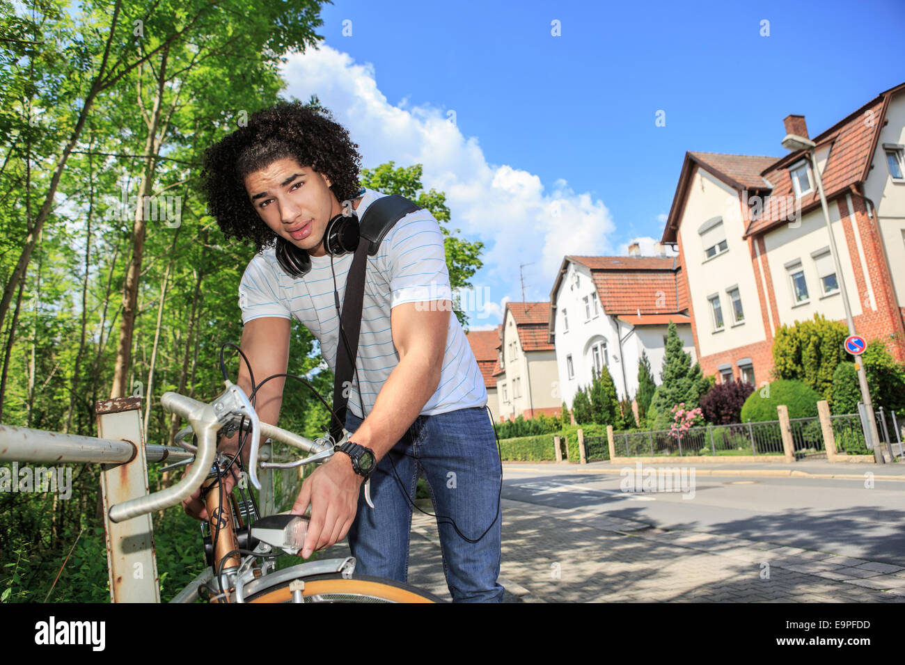 Ritratto di giovane studente maschio con una bicicletta in città Foto Stock