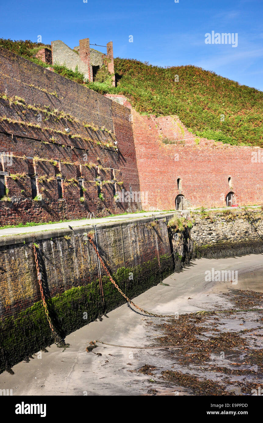 Porthgain harbour con resti di edifici industriali tra cui rosso mattone tramogge. Foto Stock