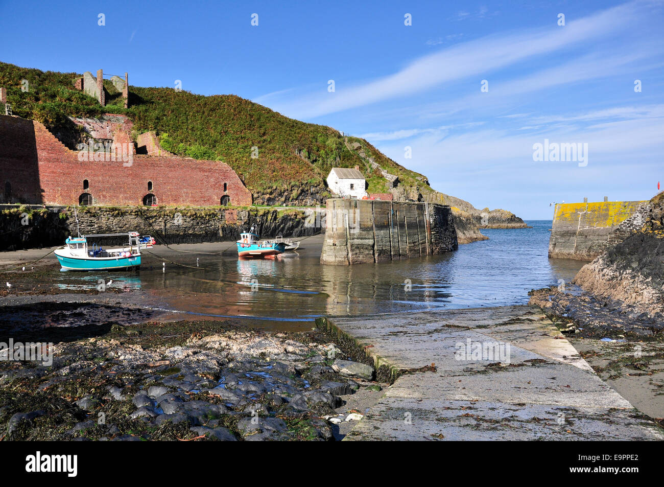 Porthgain porto, porto parete e barche, Pembrokeshire Coast su un soleggiato settembre giornata. Foto Stock