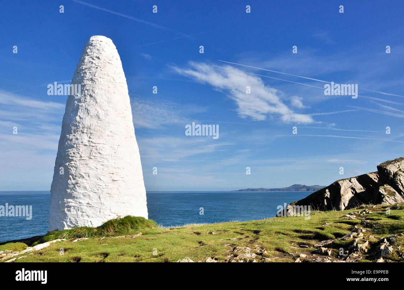 In pietra dipinta di bianco faro di navigazione a Porthgain in Pembrokeshire. White contro un cielo blu. Foto Stock