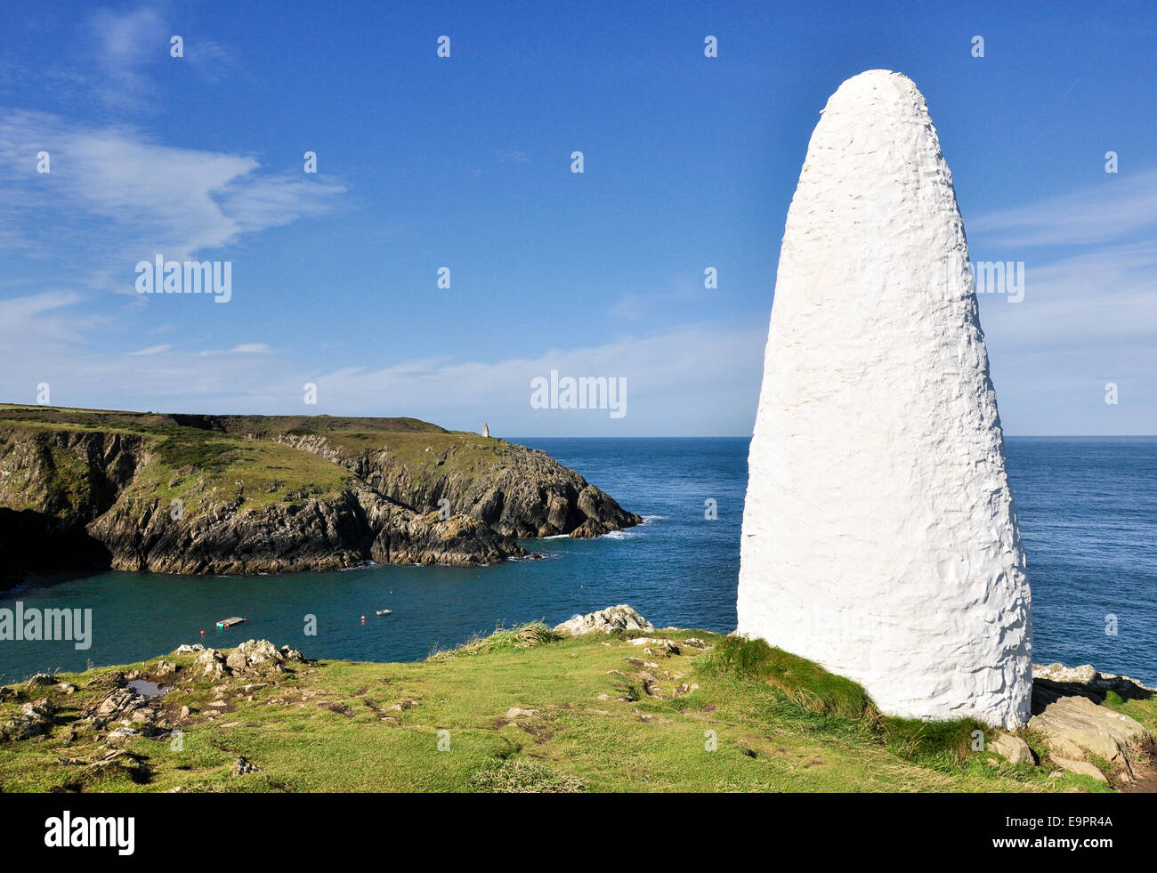 In pietra dipinta di bianco faro di navigazione a Porthgain in Pembrokeshire. White contro un cielo blu. Foto Stock