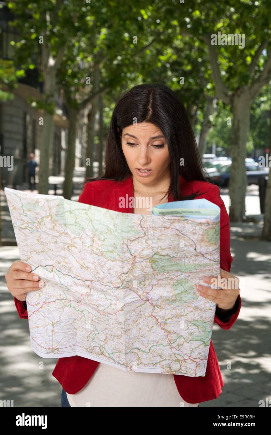 Arrabbiato brunette donna guardando una mappa a street nella città di Madrid Spagna Foto Stock