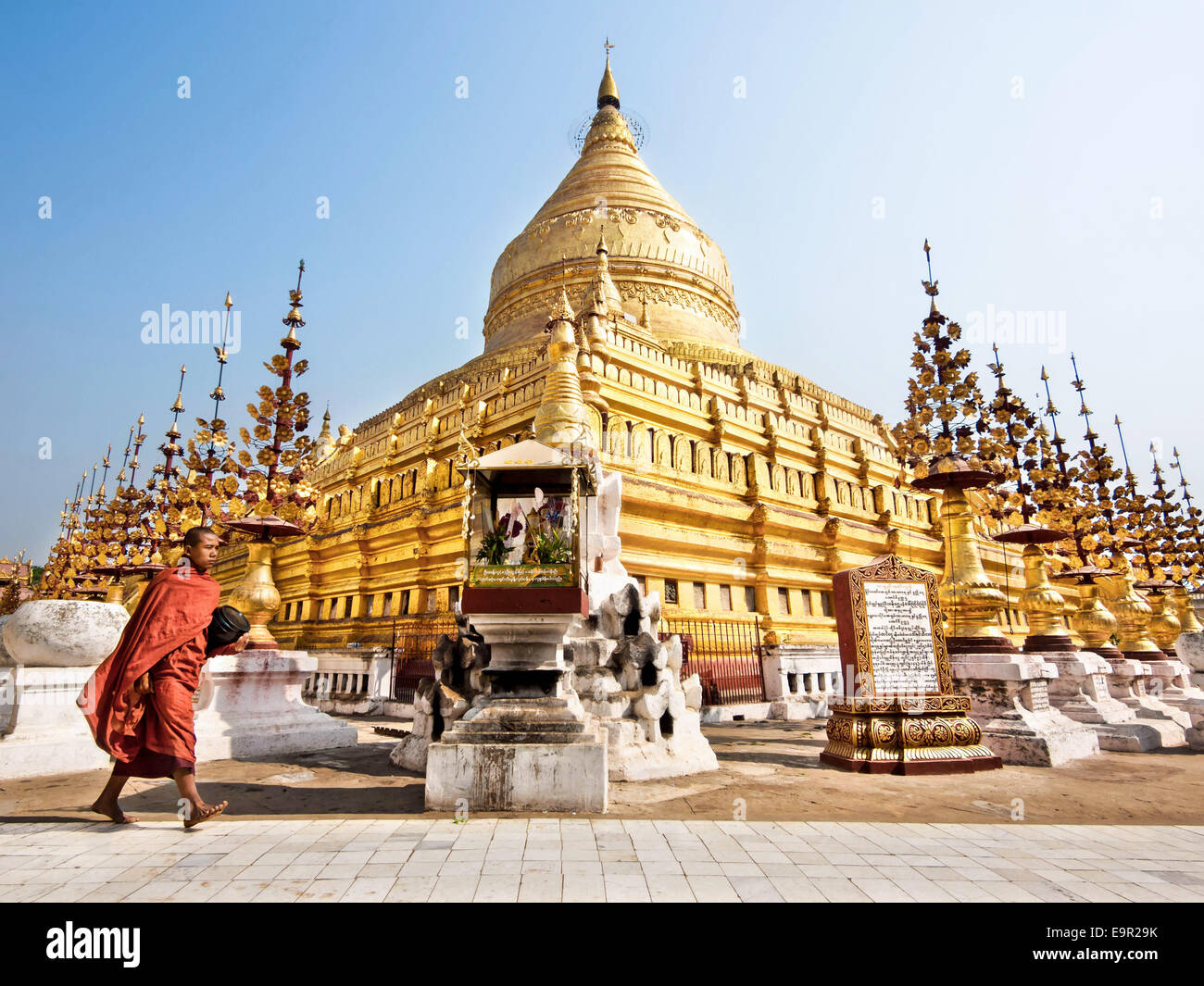 Un monaco buddista a piedi attorno a sacro Shwezigon Paya, uno del Myanmar il più venerato pagode di Bagan, Myanmar (Birmania). Foto Stock