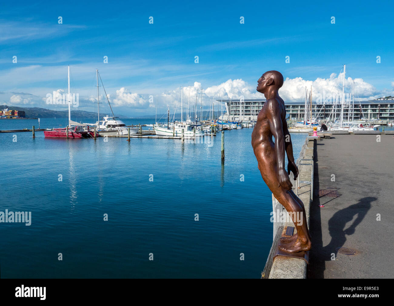 Max Patte statua del conforto del vento, bronzo figura sporgendoti dockside in prossimità della marina di Porto di Wellington, Nuova Zelanda Foto Stock