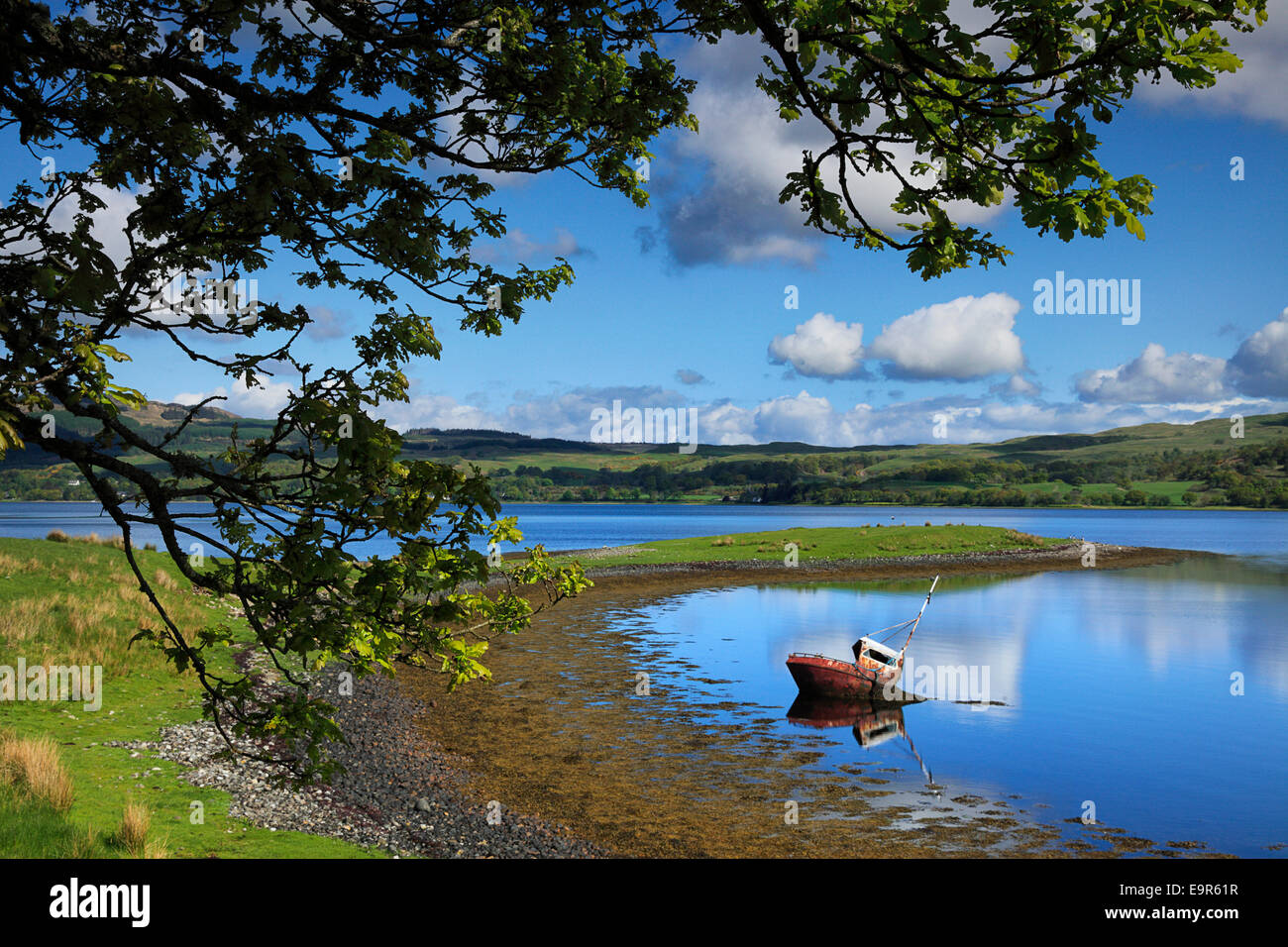 Una fatiscente barca da pesca si fonde con il litorale di Loch Etive nelle Highlands della Scozia Foto Stock
