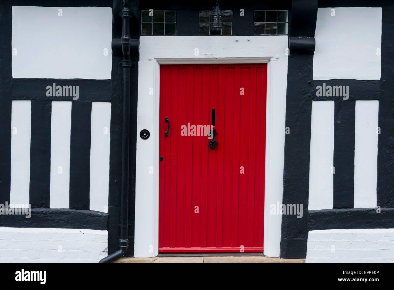 Rosso porta anteriore in un inglese tradizionale con la struttura di legno Tudor House Foto Stock