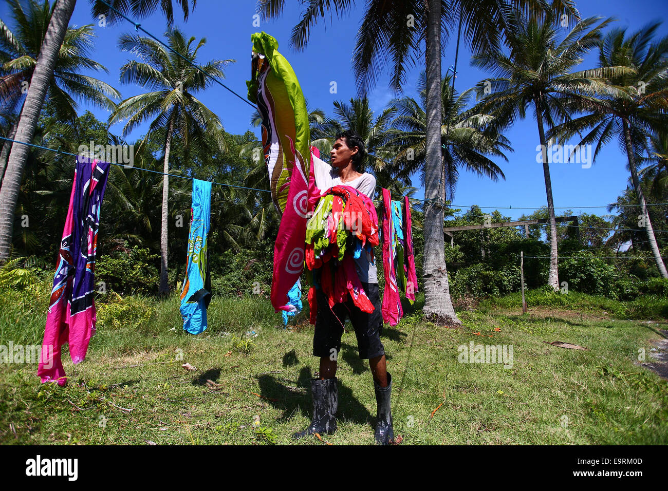 Maestro artigiano di asciugatura artigianato batik, dipinte a mano a mano sotto il sole tropicale. Foto Stock