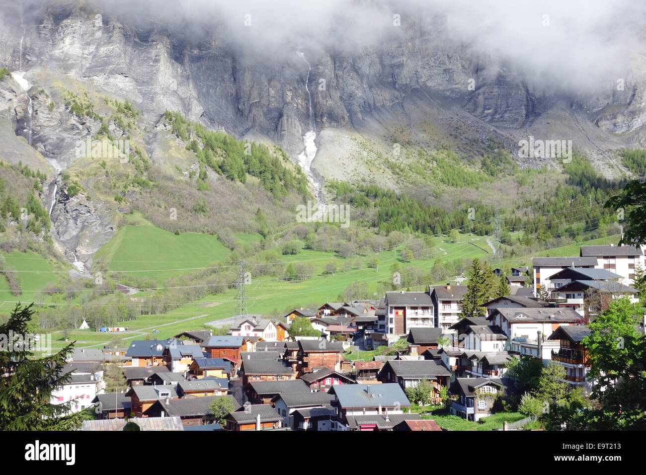 Le montagne con le nuvole e la città di Leukerbad, Svizzera Foto Stock