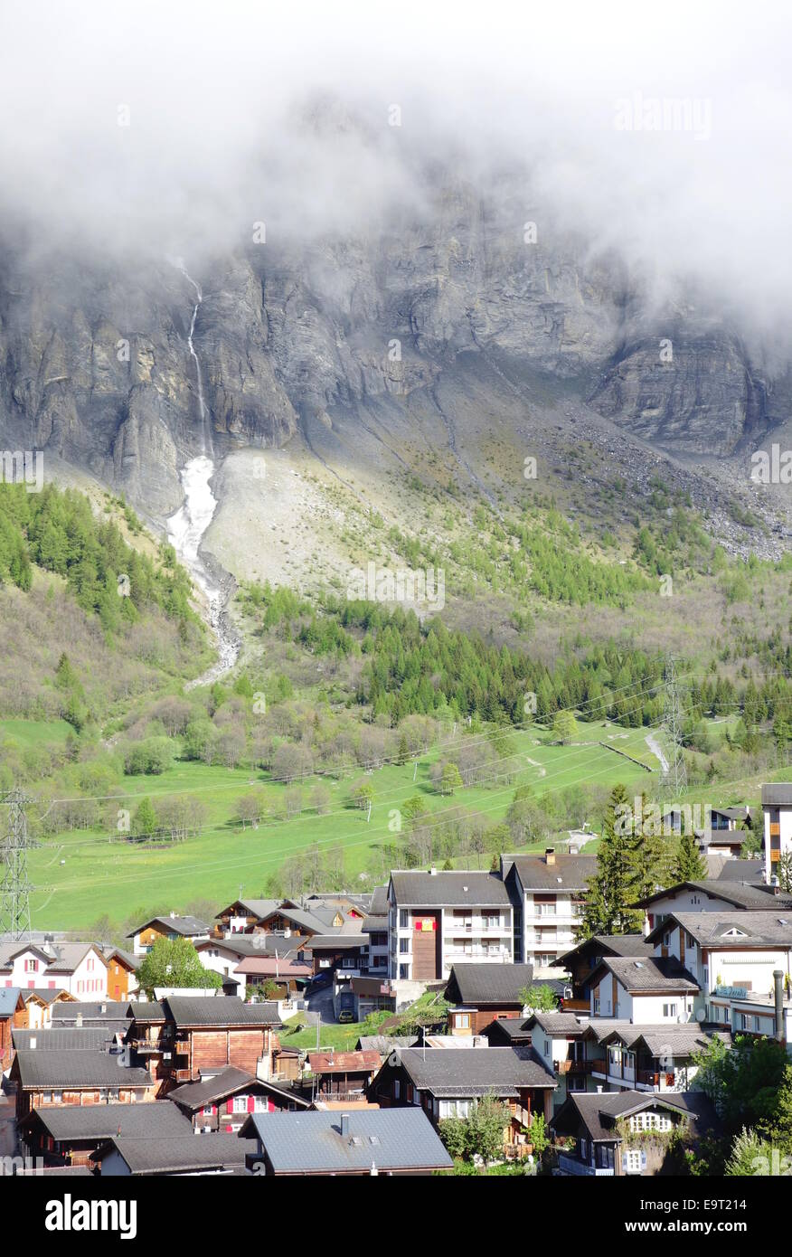 Le montagne con le nuvole e la città di Leukerbad, Svizzera Foto Stock