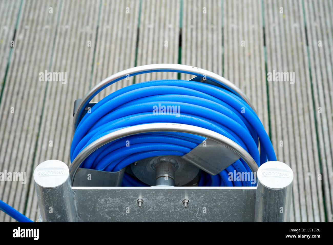 Rotolo di polietilene blu tubo flessibile in acciaio inox stand Foto Stock