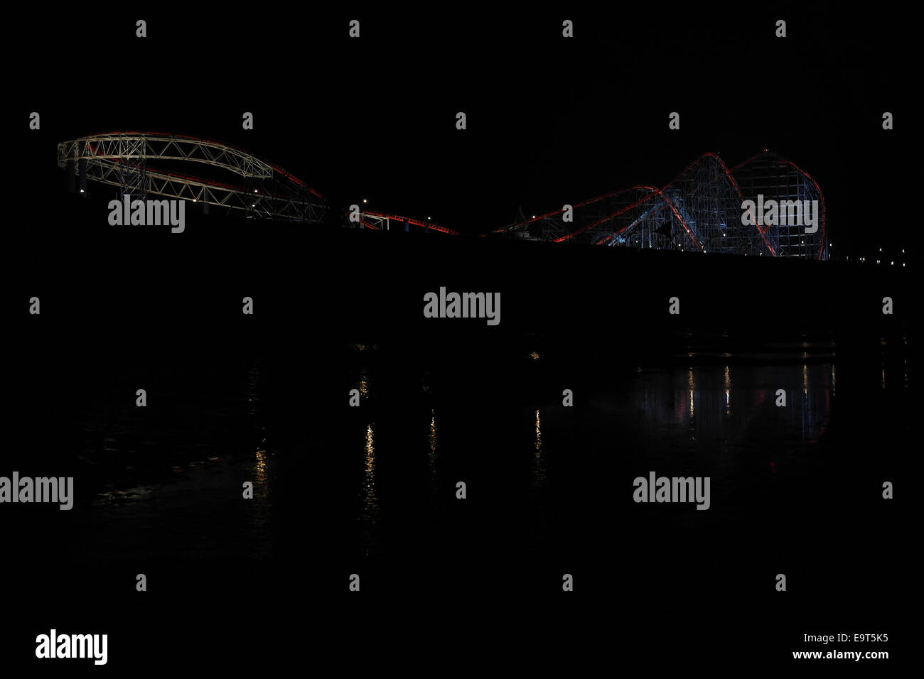 Vista notturna dal South Shore beach con riflessioni a Pleasure Beach "Big One" Rollercoaster, Luminarie di Blackpool, Regno Unito Foto Stock