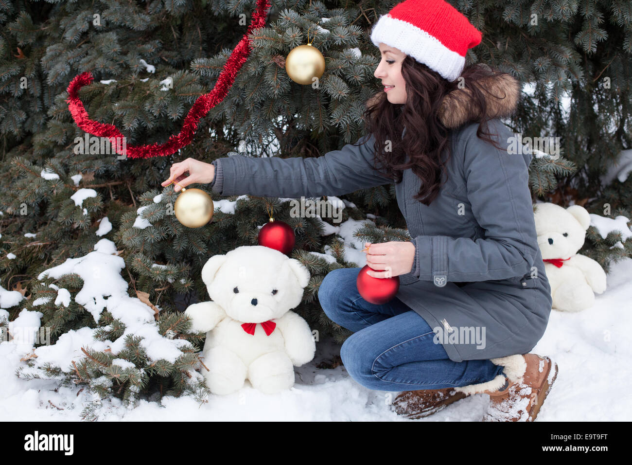 Bella giovane donna decorare albero di Natale Foto Stock