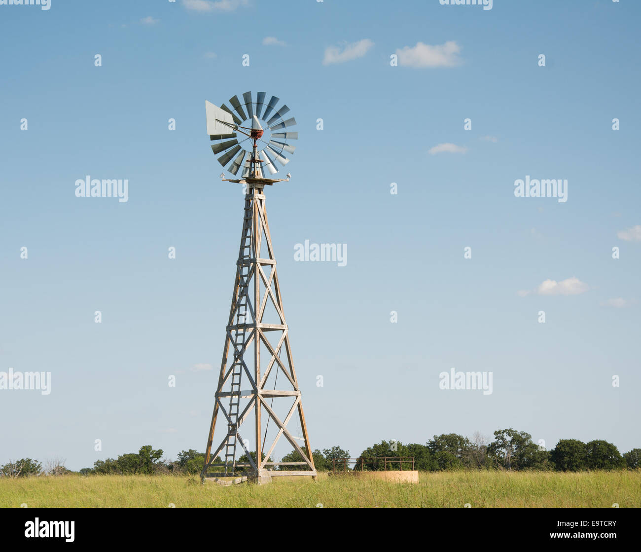 Pompa di vento con un serbatoio di acqua alla base di esso, con lame girando in venti alti Foto Stock