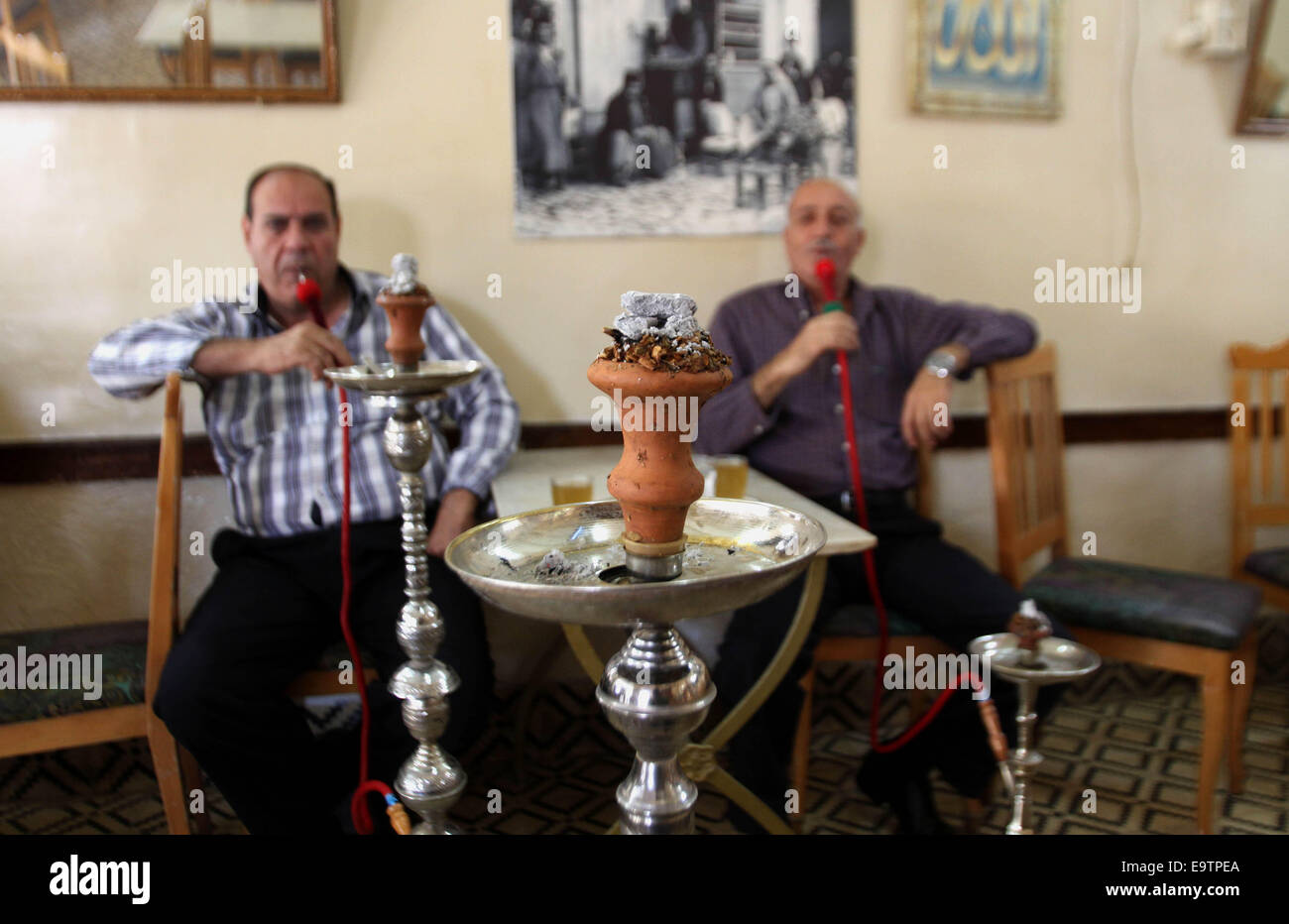 Nablus, West Bank, Territorio palestinese. 2° Nov, 2014. Un anziano gli uomini palestinesi di fumo di tabacco aromatizzato tubi di acqua o 'shisha' in corrispondenza di un cafe in Cisgiordania città di Nablus su nov. Credito: ZUMA Press, Inc./Alamy Live News Foto Stock