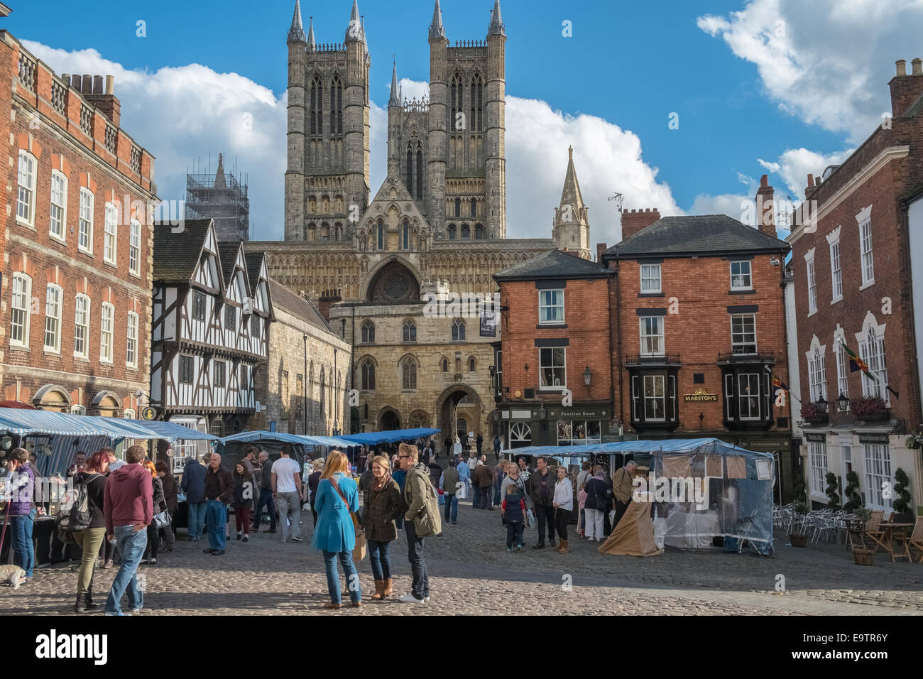 Persone in Lincoln piazza del mercato, con il duomo in background, Lincoln, Lincolnshire, England Regno Unito Foto Stock