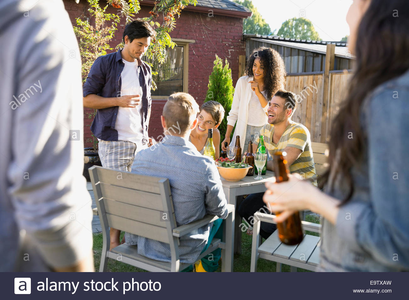 Gli amici di mangiare e bere a backyard barbecue Foto Stock