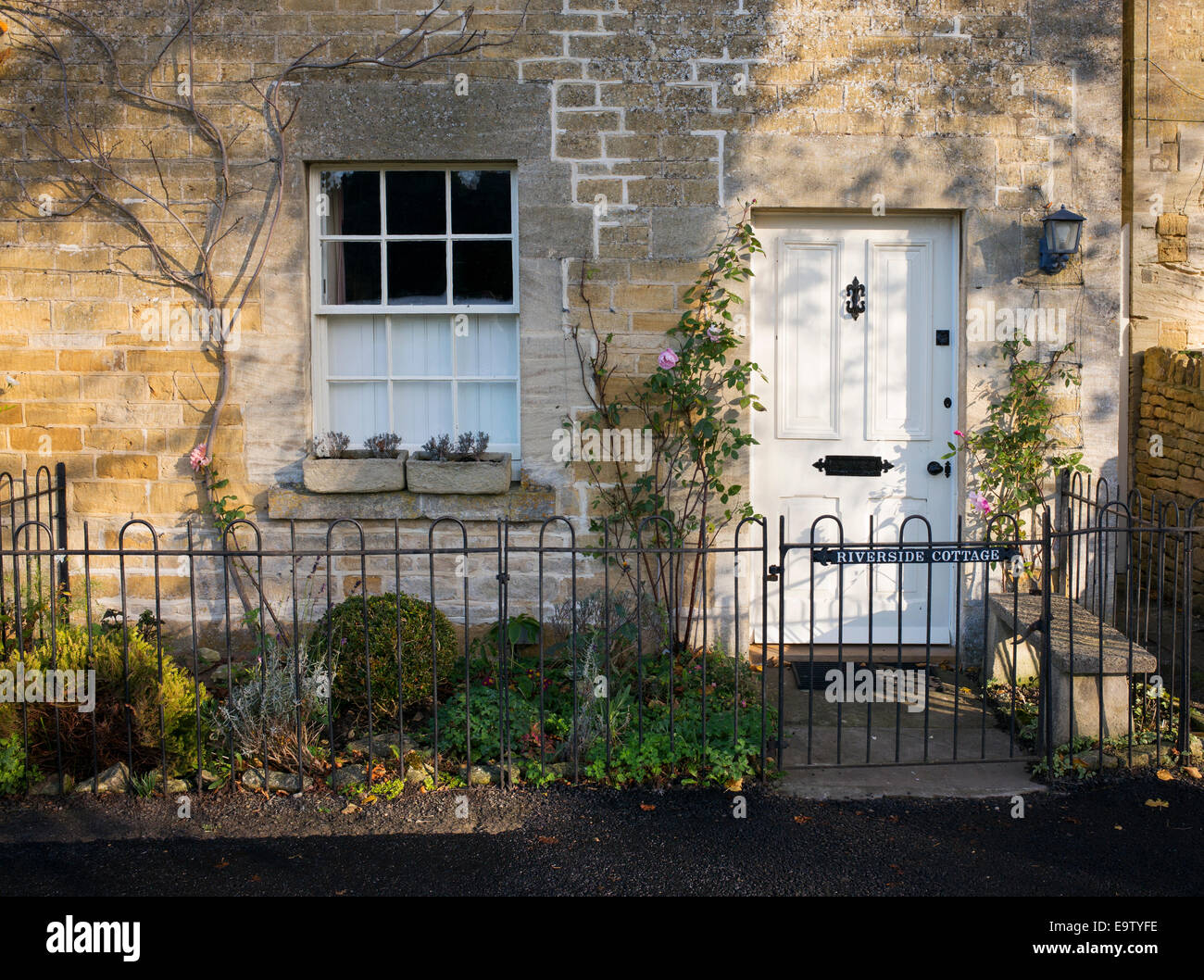 La luce del mattino e le ombre su un cottage in Lower Slaughter. Cotswolds, Gloucestershire, Inghilterra Foto Stock