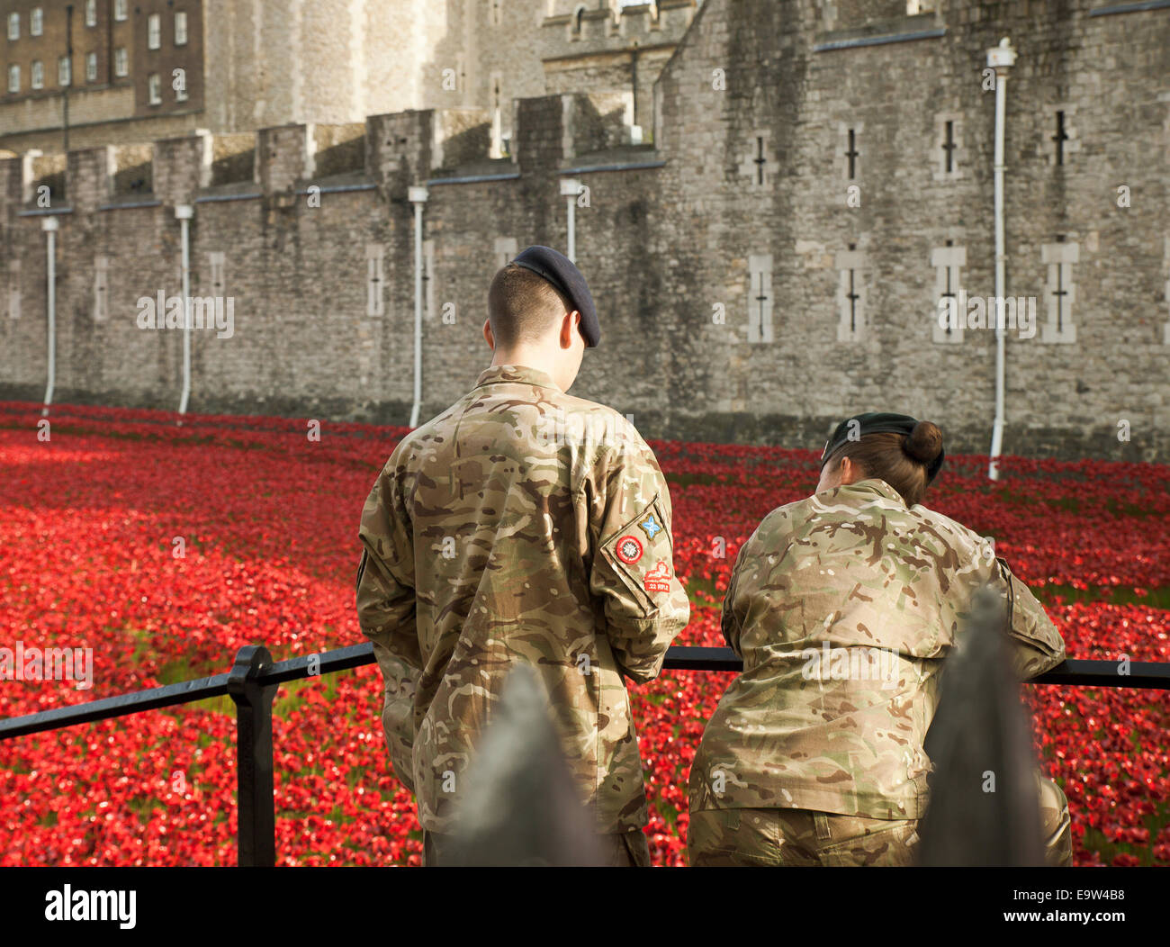 Coppia di giovani soldati visualizza la Torre di Londra papaveri. Foto Stock