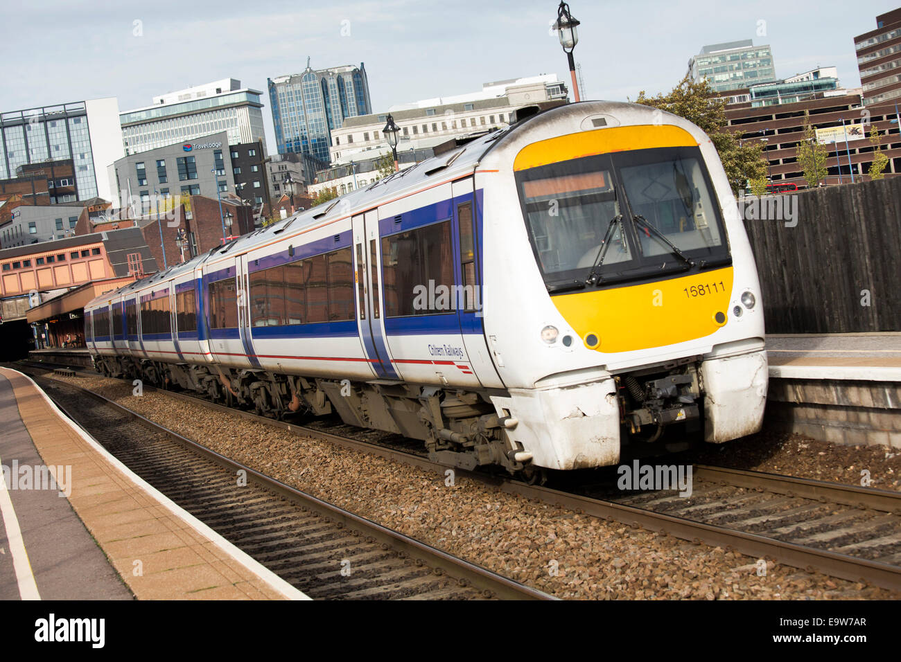 Un Chiltern Railways treno passa attraverso Moor Street Station in background è Birmingham City Centre Foto Stock
