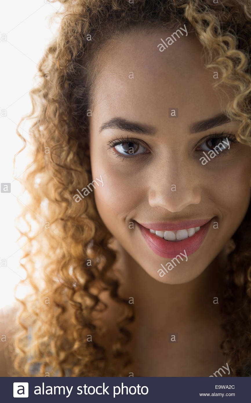 Close up di donna sorridente con capelli ricci Foto Stock