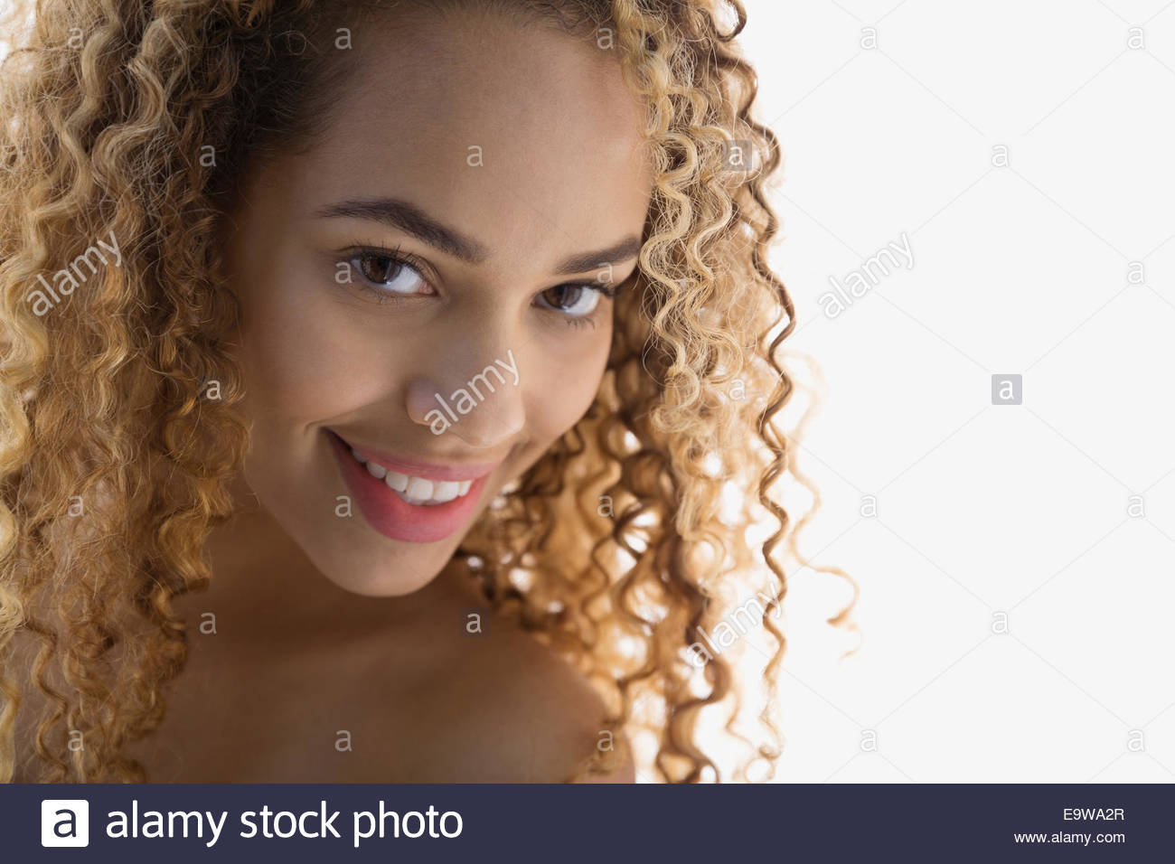 Close up di donna sorridente con capelli ricci Foto Stock