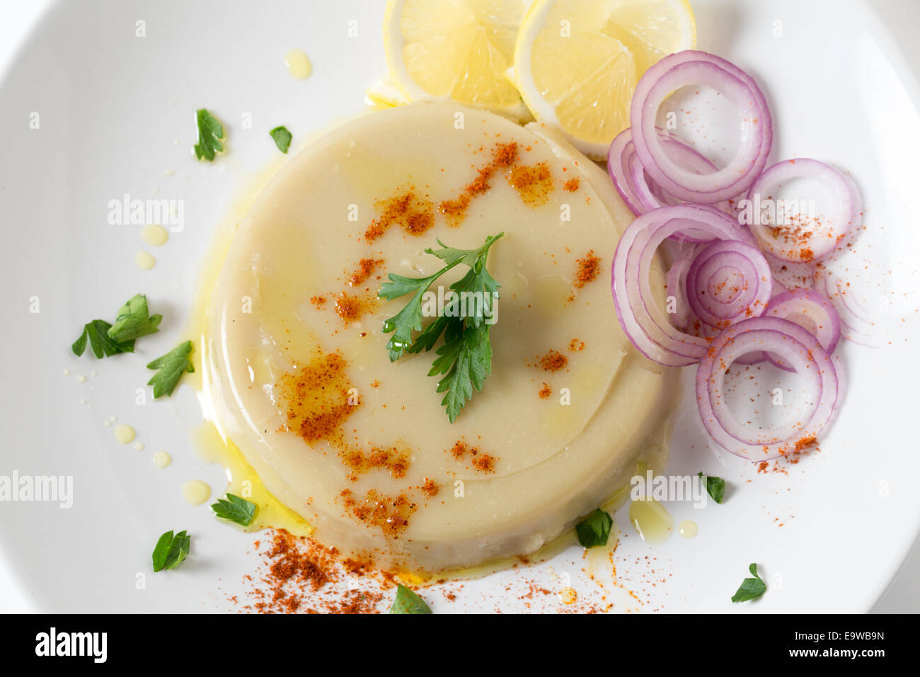 Un paté di stampati essiccato turco fava purea, guarnita con limone, cipolla, peperoncino e prezzemolo, kuru bakla ezmesi Foto Stock