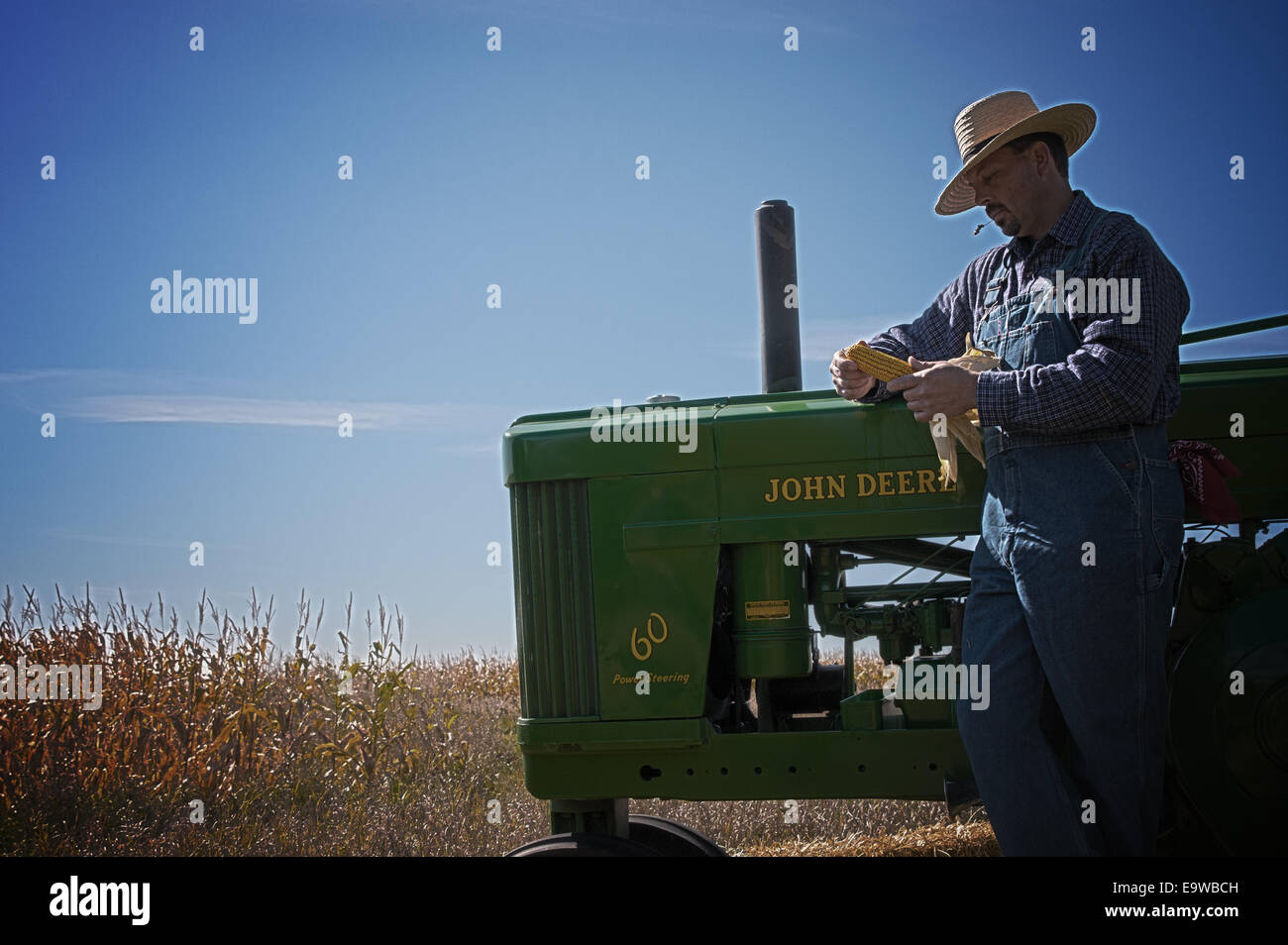 Un agricoltore di ispezionare il suo raccolto di mais con la sua annata trattore John Deere in Wisconsin Foto Stock