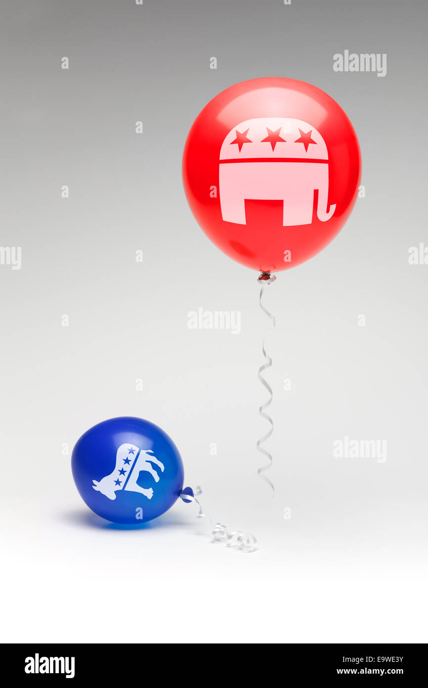 Un rosso palloncino repubblicano che fluttua sopra un parzialmente sgonfio democratica blu palloncino. Foto Stock
