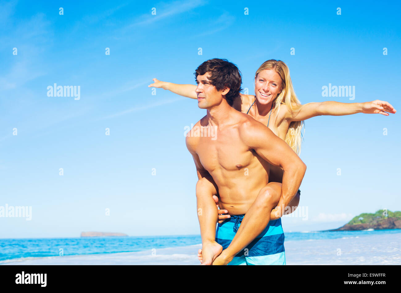 Coppia attraente avendo divertimento sulla spiaggia sabbiosa, Vacanza tropicale Foto Stock