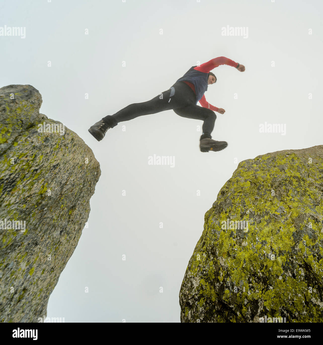 Walker fa il salto tra le rocce noto come Adamo ed Eva in occasione del vertice di Tryfan Snowdonia nel Galles Foto Stock