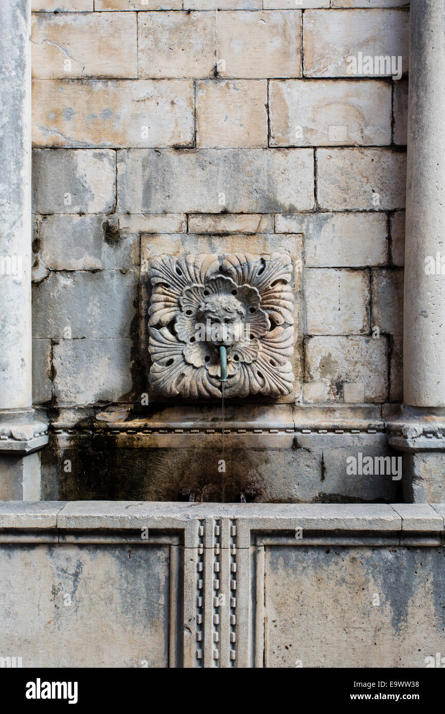 Una pietra scolpita maschera acqua zampillante dalla bocca sull'Onofrio Fontana, paese vecchio di Dubrovnik, Croazia Foto Stock