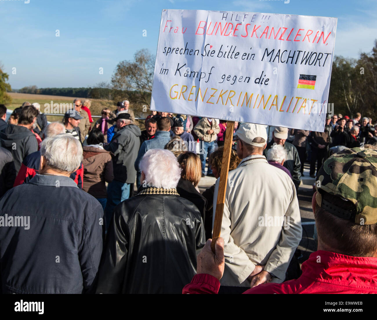 Guenter Fromm (R) da Eisenhuettenstadt proteste in apertura delle celebrazioni per il nuovo ponte tra la Germania e la Polonia oltre il fiume Neisse in Coschen, Germania, 03 novembre 2014. Il suo segno, che recita "In Coschen abbiamo costruito un ponte per la banda di ladri." si riferisce al tasso di criminalità in tedesco la regione di confine. Settanta anni dopo vi è infine un altro ponte sulla Neisse, Coschen di collegamento con la Polonia. Il ponte originale è stata distrutta durante la Seconda Guerra Mondiale. La base per la costruzione proviene da un governo accordo tra la Germania e la Polonia. Dal costo totale di 5.4 Foto Stock