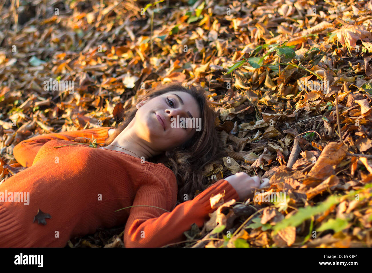 Ritratto di una donna autunno giacente su foglie outdoor shot Foto Stock
