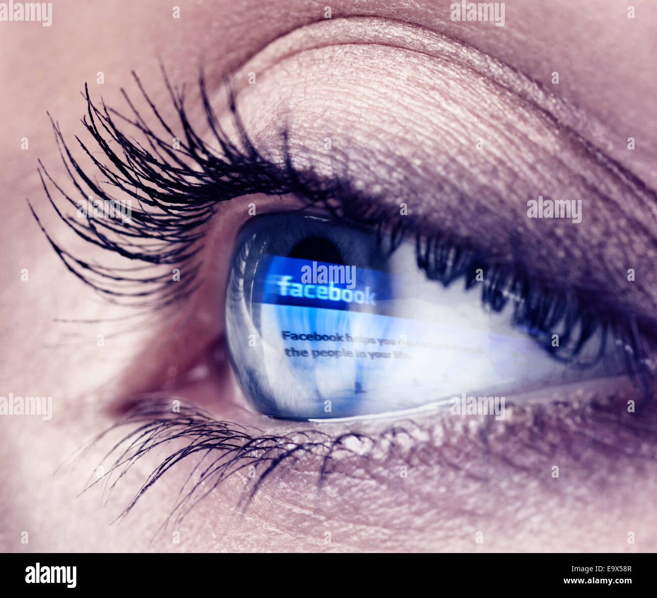Primo piano di una giovane donna occhio blu con il logo di Facebook che riflette in esso Foto Stock